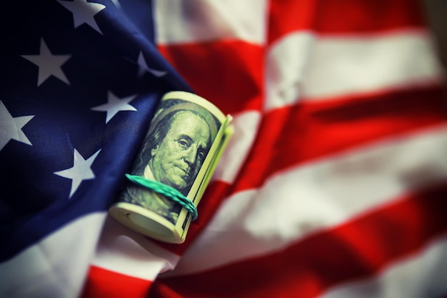 Американский полосатый флаг и стопка стодолларовых купюр Финансовый центр мира