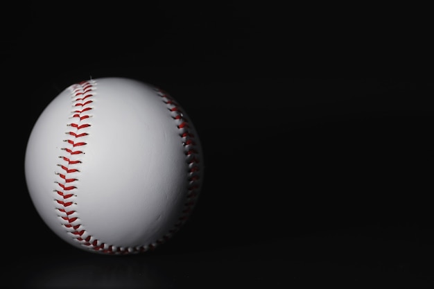 American traditional sports game. Baseball. Concept. Baseball ball and bats on a black table.