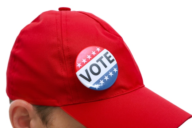 American votes concept Voting badge pined on red cap close up