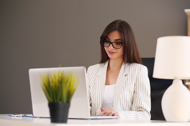 American woman working laptop. Business woman busy working on laptop computer in the office.