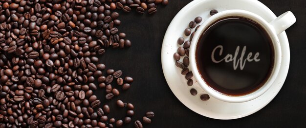 Americano Top view of a cup of coffee on the background of roasted coffee beans Lettering Coffee