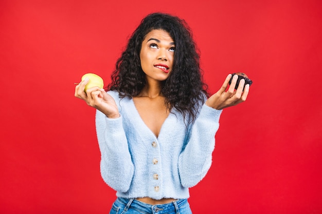 Amerikaans Afrikaans meisje dat tussen appel en koekje kiest