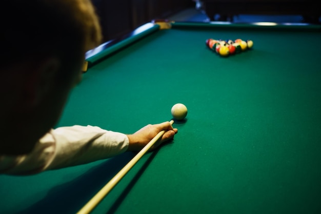 Amerikaans biljart Man speelt biljart snooker Speler bereidt zich voor om te schieten terwijl hij de speelbal raakt