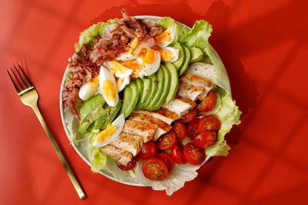 Amerikaans eten Cobb-salade met avocado-spek tomaat gegrilde kippeneieren oGezond eten Raamschaduw
