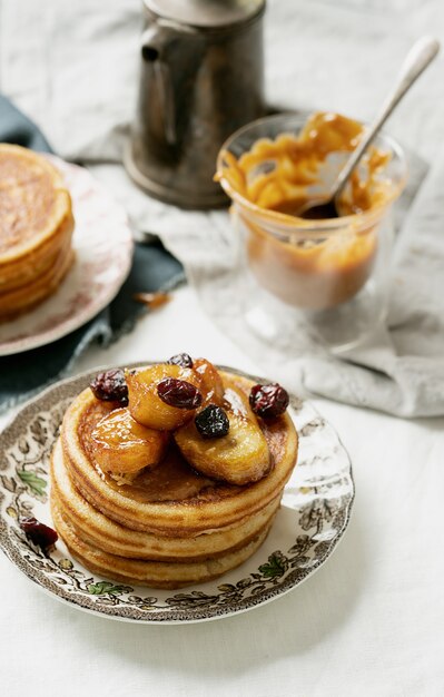 Amerikaans ontbijt, brunch, lunch, maaltijdpannekoeken met pindakaas en bananen over een wit servet. Veganistisch eten concept