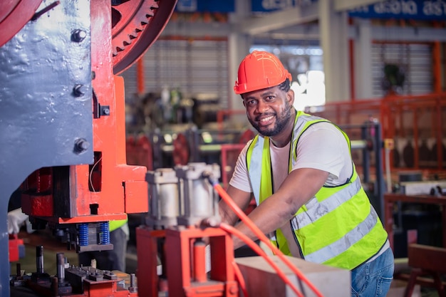 Amerikaanse arbeider die in fabriek werkt Afro-Amerikaanse zwarte man is industriële machinefabriek voor operatorbesturing