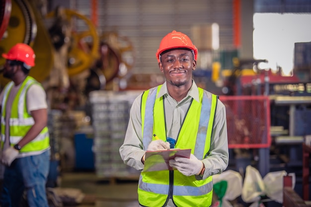 Amerikaanse arbeider die in fabriek werkt Afro-Amerikaanse zwarte man is industriële machinefabriek voor operatorbesturing