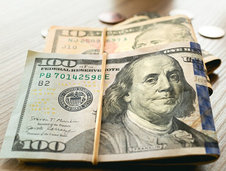Amerikaanse dollarbiljetten op houten meubels in close-upfotografie