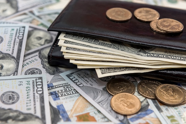 Foto amerikaanse dollars en centen in donkere lederen portemonnee. financiële bedrijfsconcept.