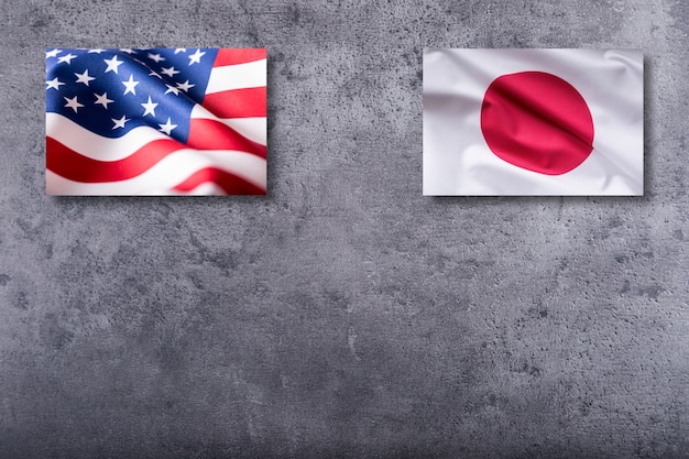 Amerikaanse en Japanse vlaggen. Vlag van de VS en Japan op concrete achtergrond.