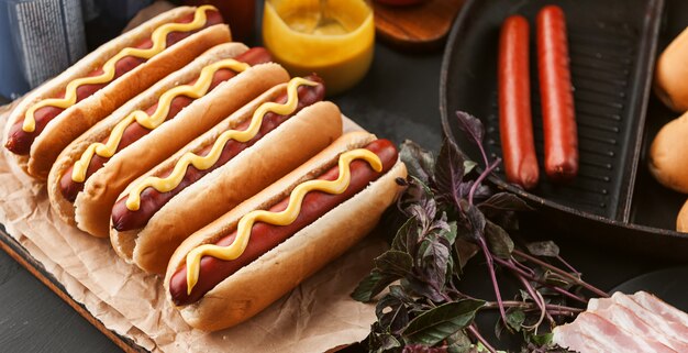 Amerikaanse hotdog met ingrediënten op een donkere houten oppervlak