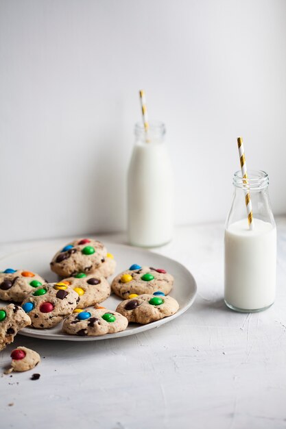 Amerikaanse koekjes met gekleurde snoepjes en flessen melk