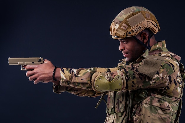 Amerikaanse man in camouflagepak gericht met een pistool