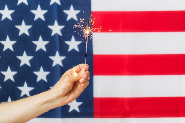 amerikaanse onafhankelijkheidsdag, patriottisme, feestdagen en mensenconcept - close-up van hand met sterretje boven nationale vlag