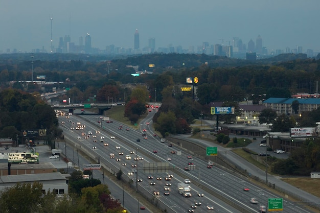 Amerikaanse snelweg met snel rijdende auto's en vrachtwagens en hoogbouw wolkenkrabbers van de stad Atlanta in de staat Georgia Uitzicht van bovenaf op de Amerikaanse transportinfrastructuur Atlanta USA 14 november 2022