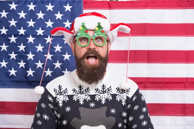 Amerikaanse traditie. Kerstman op Amerikaanse vlag. Vier kerst en nieuwjaar. Kersttraditie uit de VS. Trots op mijn land. Winter vakantie seizoen. Amerikaanse man sloot zich aan bij vrolijke viering.