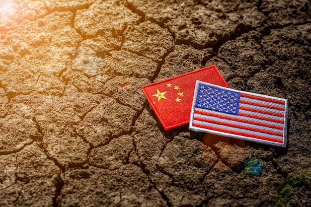 Amerikaanse vlag en de vlag van china op verlaten gebarsten grond.