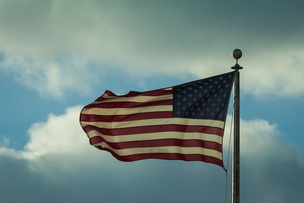 Foto amerikaanse vlag zwaaien voor bewolkte hemel
