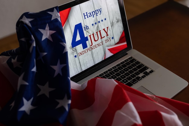 Foto amerikaanse vlaggen met opschrift happy independence day op laptop