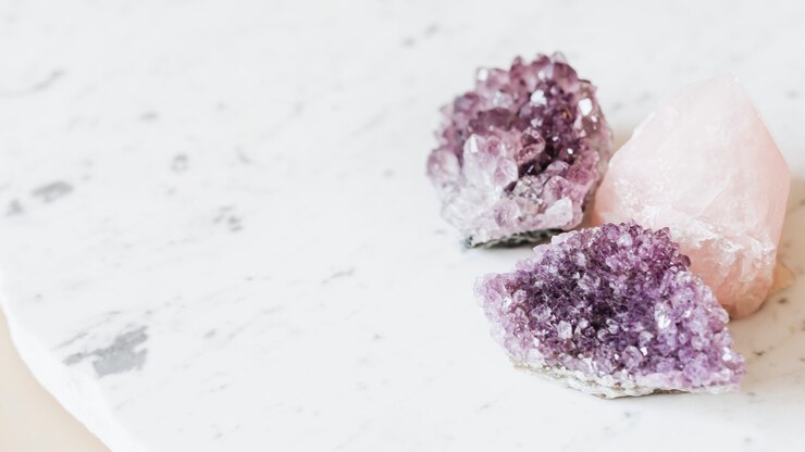 Photo amethyst and rose quartz crystals on a marble countertop