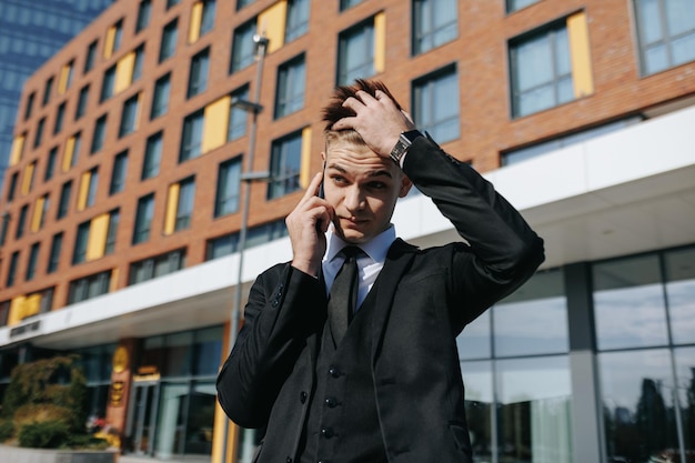 Amid the urban hustle a distressed young man in business attire engages in a conversation on his