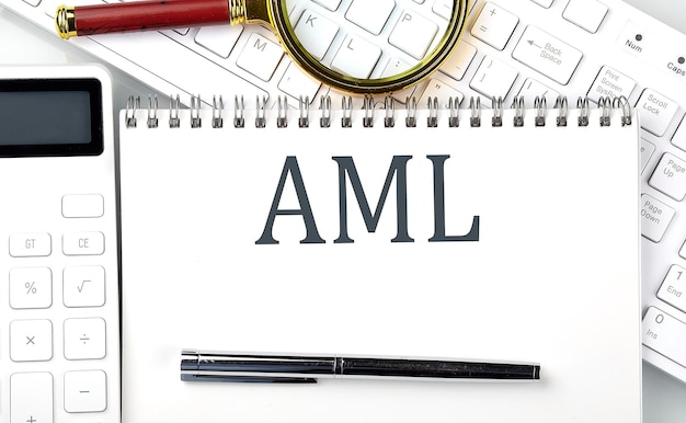 Photo aml text on notepad with calculator and keyboard,business concept