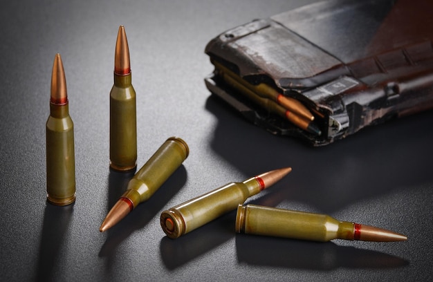 Ammunition for a automatic rifle on black surface with a magazine