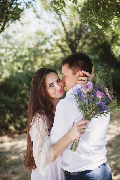 Amorous happy couple stands hugging in the forest