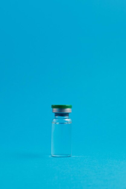 Ampoule with medicine on blue background