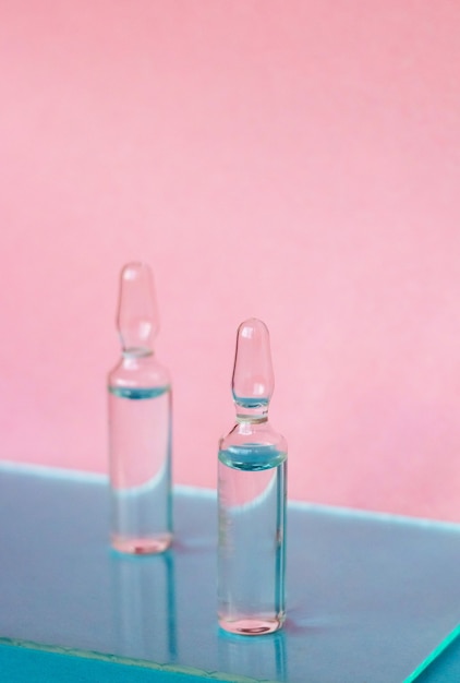 Ampoules for medical and cosmetic products on a pink background Substance solution for injection