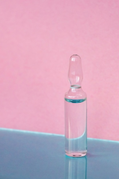 Ampoules for medical and cosmetic products on a pink background Substance solution for injection