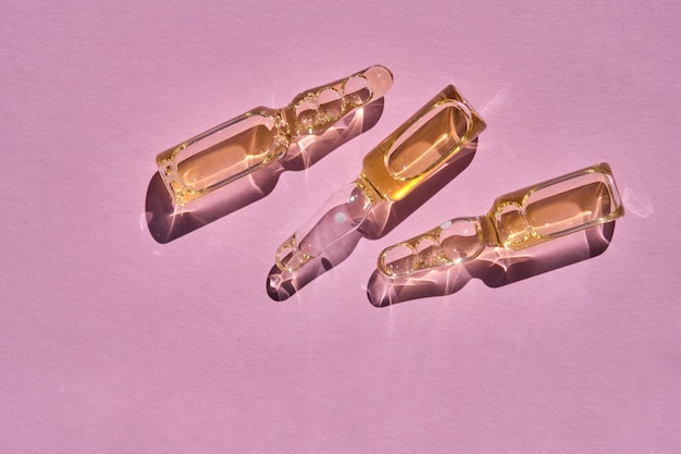 Photo ampoules on a pink background on the sun