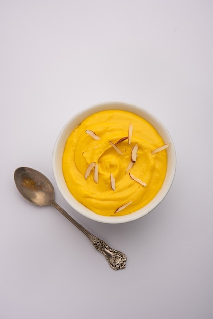 Amrakhand는 Alphonso 맛 요구르트 또는 Shrikhand, 말린 과일 및 사프란과 함께 제공되는 인기있는 인도 과자입니다.