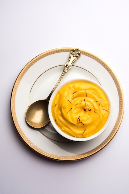 amrakhand or mango shrikhand or srikhand is popular indian dessert served with saffron toppings in a bowl