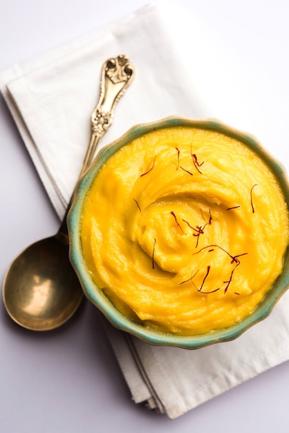 amrakhand or mango shrikhand or srikhand is popular indian dessert served with saffron toppings in a bowl