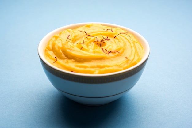 Amrakhand 또는 Mango Shrikhand 또는 srikhand는 사프란 토핑과 함께 그릇에 제공되는 인기 있는 인도 디저트입니다.