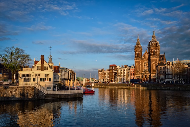 アムステルダムの運河と日没の聖ニコラス教会