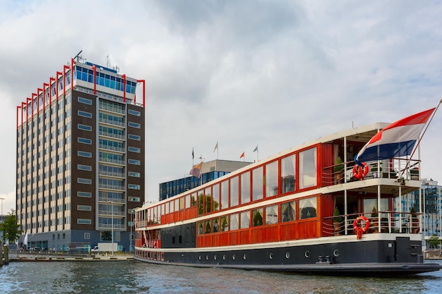 Barca sul canale di amsterdam e costruzione moderna olanda