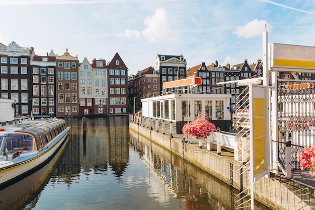 Amsterdam canal cruise ship with Netherlands traditional house in Amsterdam Netherlands