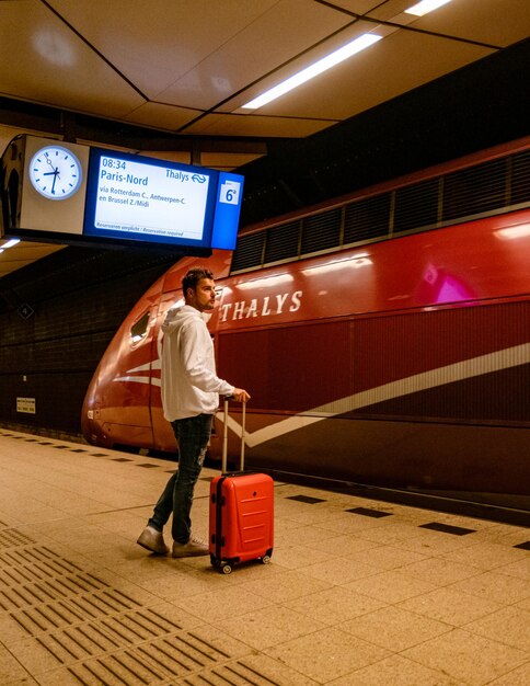 Amsterdam netherlands youn men waiting for thalys train to\
paris in the morning at schiphol station