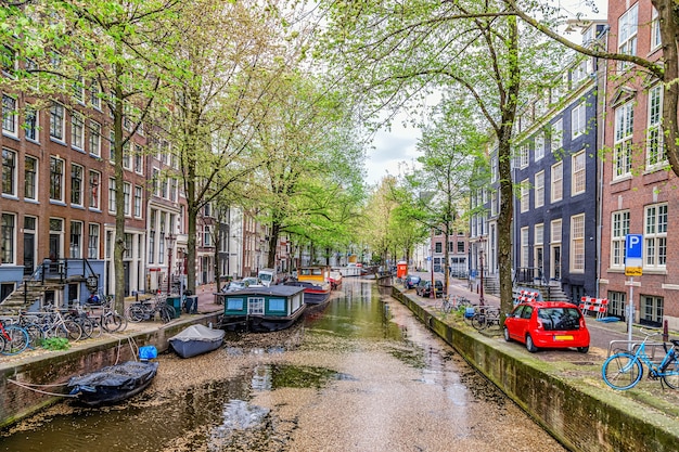 Amsterdamse rondvaartboten en middeleeuwse typisch Nederlandse huizen in een lentedag Amsterdam Nederland