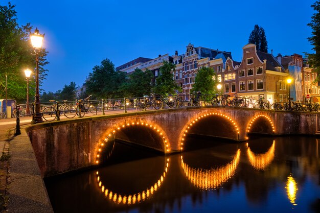 Canale di amsterdam, ponte e case medievali la sera