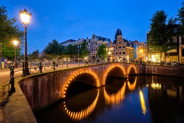 Amterdam kanaalbrug en middeleeuwse huizen in de avond