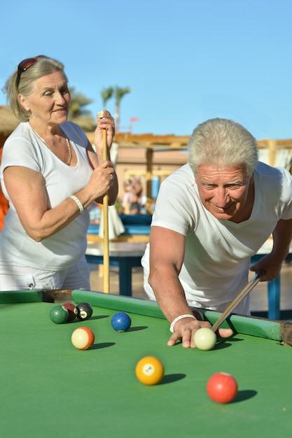 Amusant oud stel op vakantie biljart