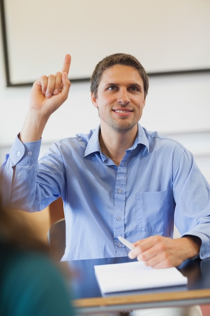 Amused male mature student raising his hand