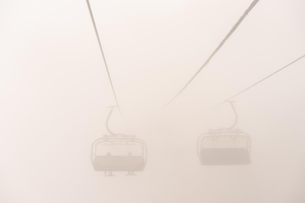 Amusement park rides excursion with ski lift in the fog natural park background abstract scenic land