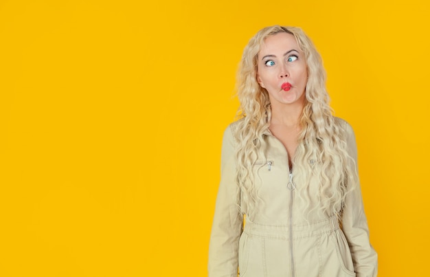 Photo amusing, playful cute woman, showing her cheerful side, playing charades, imitating fish, folding her lips and squinting