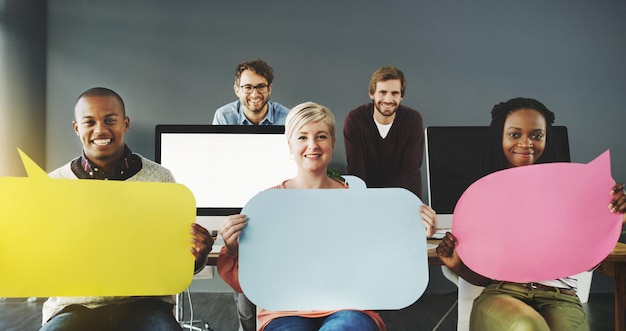 Фото Объявление из офиса. снимок разношерстной группы людей, держащих речевые пузыри в современном офисе.