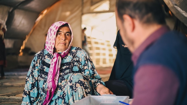 写真 シリア の 難民 キャンプ の 中 の 臨時 診療所 で 医療 を 受け て いる 高齢 の 女性