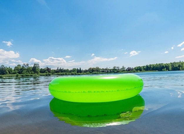 Фото Создан надувной круг для плавания на поверхности воды неподвижного озера на закате.